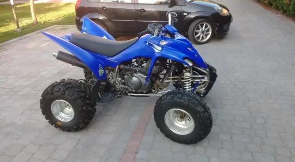 Niebieski Yamaha Raptor 350, quad z mocnym silnikiem, gotowy do jazdy. Ile ma koni? To pytanie dla fanów off-roadu!