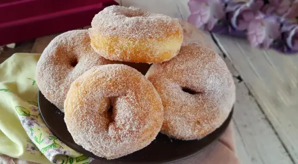 Graffe napoletane senza patate, soffici e dorate, ricoperte di zucchero. Un dolce che profuma di tradizione.