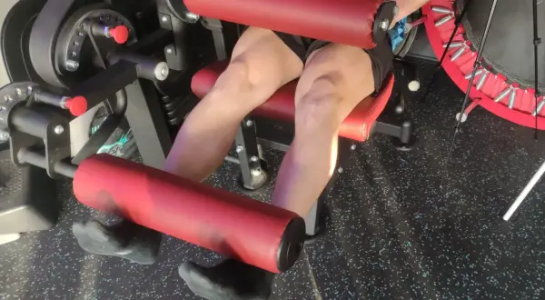 Persona esegue esercizi per rinforzare le ginocchia su una macchina da palestra.