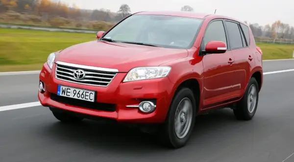 Czerwony SUV do 30 tys. na drodze, z widocznym numerem rejestracyjnym WE 966EC.