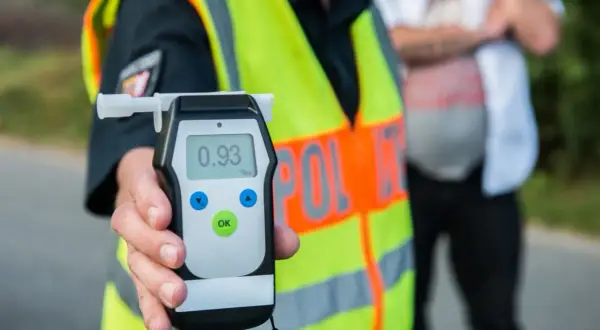 Policjant pokazuje alkomat z wynikiem 0.93 promila. To znacznie przekracza dopuszczalną ilość alkoholu we krwi.