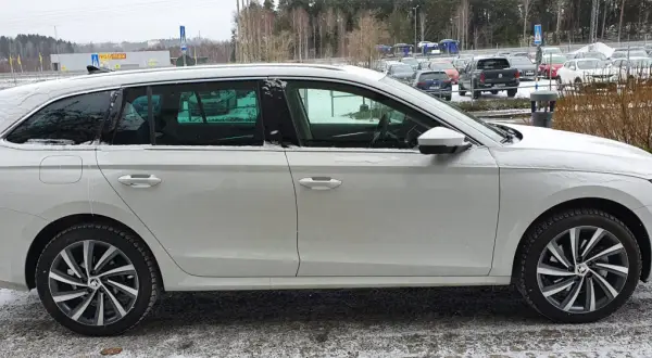 Vit Skoda Octavia laddhybrid parkerad i snö. Bilen har mörka fönster och snygga fälgar.