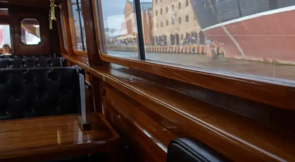 Eleganckie wnętrze statku w Gdańsku, z widokiem na zabytkowe kamienice i cumujący statek. Idealne miejsce na romantyczny wieczór, oferujące wyjątkowe gdańskie atrakcje dla dorosłych.