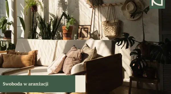 Przytulny salon w stylu boho z mnóstwem roślin, plecionymi dodatkami i słonecznymi promieniami.