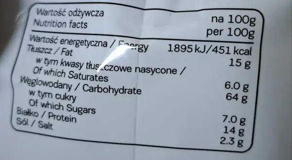 Etykieta z wartościami odżywczymi: 451 kcal na 100g. Tłuszcz 15g, węglowodany 64g, białko 7g. Idealne na 7days kcal.