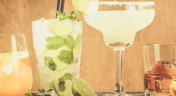 Fyra klassiska drinkar: en Mojito, en Margarita med saltkant, en orange drink och en whisky med apelsinskal.