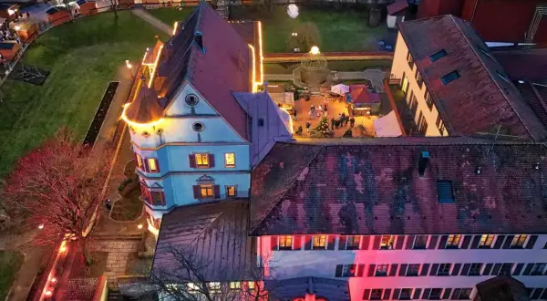 Luftaufnahme der Treuchtlinger Schlossweihnacht mit beleuchteten Buden und einem Weihnachtsbaum.