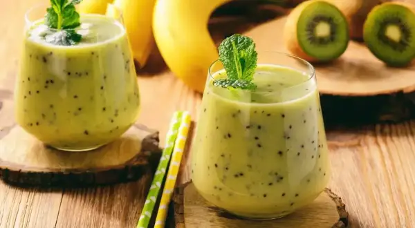 Dwa pyszne koktajle na przytycie z kiwi i bananem, ozdobione miętą. Idealne na zdrowy przyrost masy.