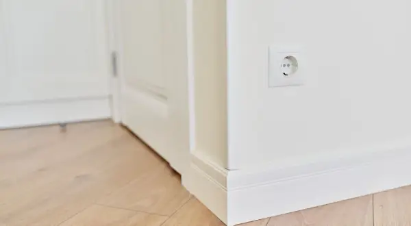 Los rodapiés blancos, igual que las puertas, crean un contraste elegante con el suelo de madera clara.