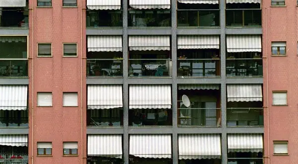 Facciata di un palazzo con balconi e tende da sole. Una possibile ripartizione spese facciata senza millesimi potrebbe considerare l'uso delle tende.