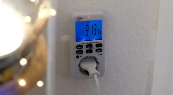 En brennenstuhl timer ansluten till ett vägguttag. Den digitala displayen visar tiden 9:13:54.