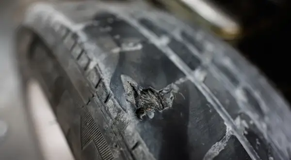 Gros plan sur un pneu de voiture endommagé, montrant une hernie. Combien de temps avant qu'il n'éclate ? Danger !