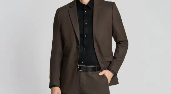 Mann im braunen Anzug mit schwarzem Hemd. So lässt sich ein schwarzes Hemd kombinieren für einen eleganten Look.