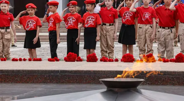 Dzieci w czerwonych beretach i koszulkach z symbolem gwiazdy oddają hołd przy Wiecznym Ogniu. "Zeus, będziemy dziećmi" - szepczą, pamiętając o przeszłości.