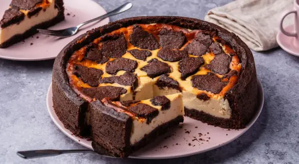 Ein saftiger russischer Zupfkuchen von Sally, mit dunklem Schokoboden und cremiger Füllung, belegt mit zupfartigen Schokostückchen.
