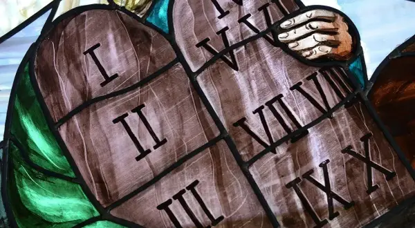 Fragment witrażu przedstawiający kamienne tablice z rzymskimi cyframi od I do X.