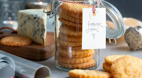 En burk med staplade parmesan kex, en bit blåmögelost och juldekorationer. Perfekt för julens fika!