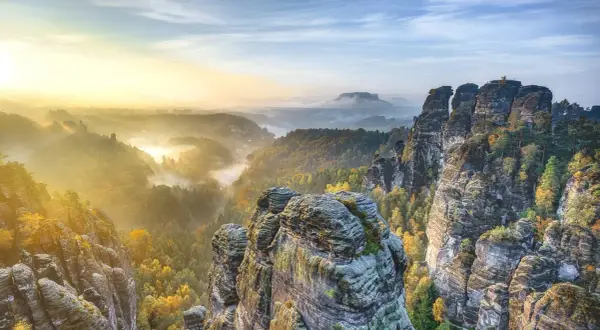 Morgendlicher Nebel über Felsformationen und Wäldern in der Sächsischen Schweiz. Ein perfekter Ort für einen Urlaub in Sachsen.