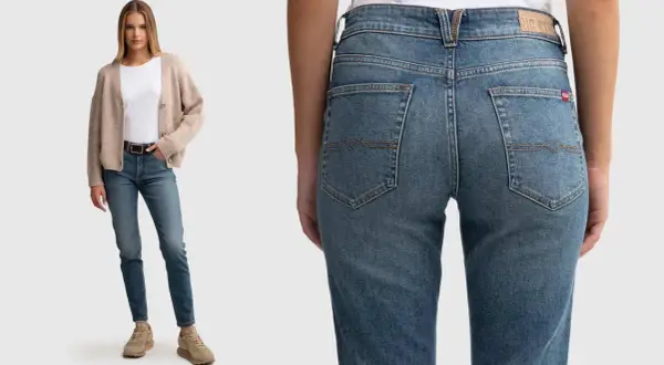 Modelka w beżowym kardiganie i białej bluzce prezentuje jeansy: spodnie szerokie w udach, wąskie w łydkach.