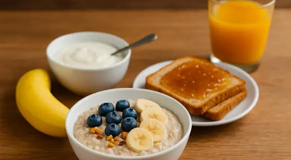 Colazione ideale: porridge con frutta, yogurt, toast e succo d'arancia. Perfetto per sapere cosa mangiare prima di correre 10 km.
