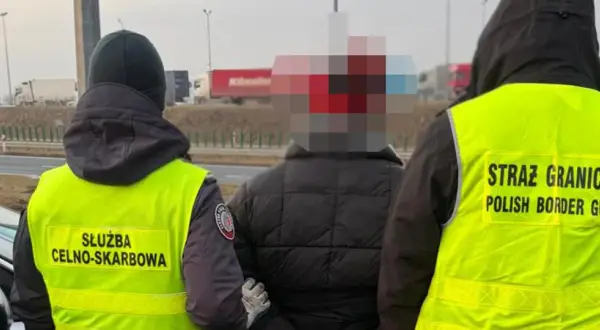 Funkcjonariusze Straży Granicznej i Służby Celno-Skarbowej zatrzymują osobę na drodze.