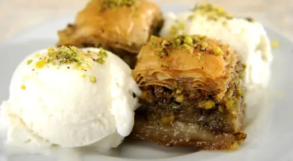 Délicieux baklava recette servi avec de la glace à la vanille, saupoudré de pistaches concassées.