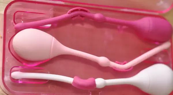 Tre knipkulor i rosa och vitt, förberedda för användning, kanske för en gravid kvinna som vill stärka bäckenbotten.
