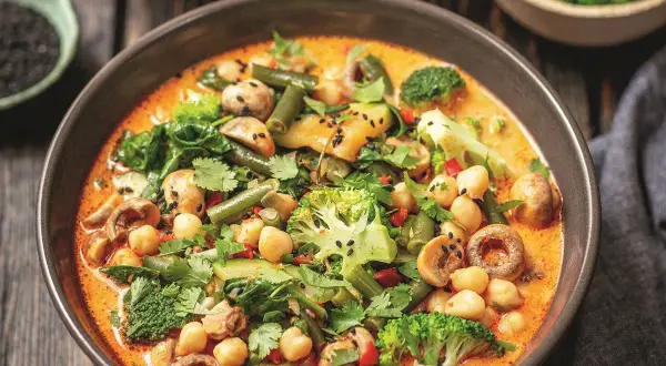 Aksamitne curry z ciecierzycy z brokułami, fasolką szparagową i grzybami, posypane czarnym sezamem.