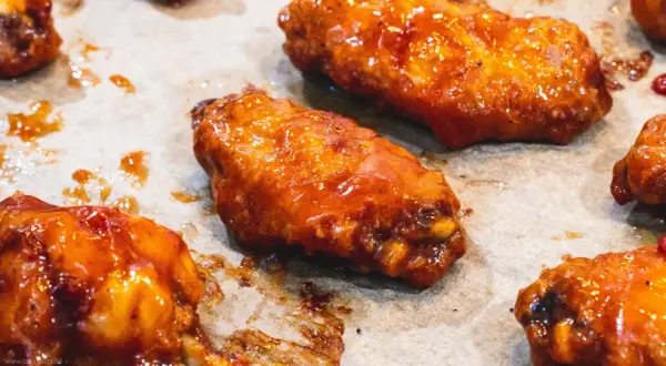 Saftige Hähnchenflügel in einer glänzenden, würzigen Marinade, bereit zum Genuss.