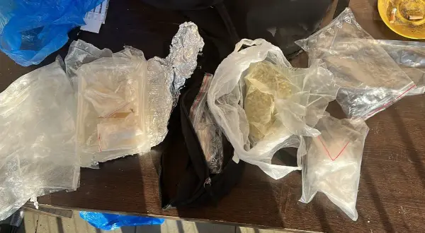 Różne substancje w foliowych i plastikowych opakowaniach na drewnianym stole.