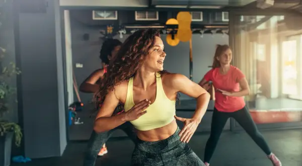 Kobiety tańczące w rytm muzyki na zajęciach zumba. To świetny sposób na aktywność fizyczną i dobrą zabawę.