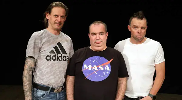 Trzech mężczyzn na czarnym tle. Jeden w koszulce Adidas, drugi w koszulce z logo NASA, trzeci w białej koszulce.