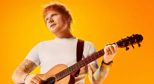 Ed Sheeran z gitarą, gotowy na koncerty w 2025 roku.