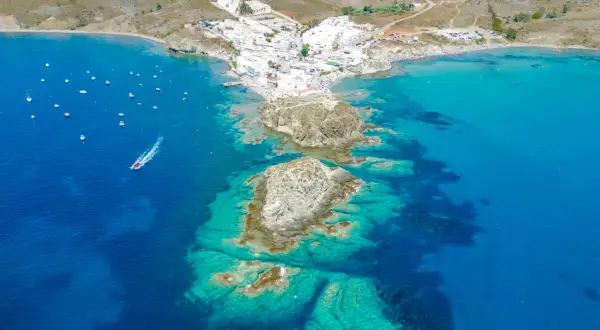 Vista aérea de la isleta de Cabo de Gata, con casas blancas, barcos y aguas cristalinas.