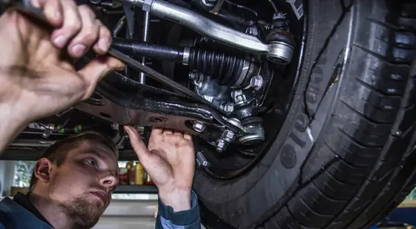 Mechanik pracuje pod samochodem. Prawdziwa historia klienta, który stracił gwarancję przez wymianę klocków poza ASO.