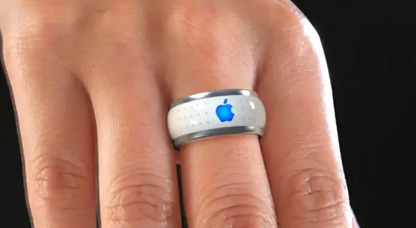 Bague connectée Apple, blanche avec logo bleu lumineux, portée au doigt.