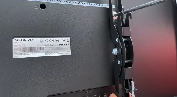 Montaż telewizora na ścianie bez uchwytu? To możliwe! Wkręcanie elementów mocujących do tyłu telewizora Sharp.
