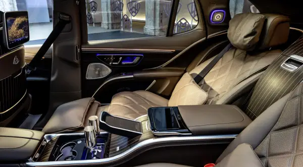 Luksusowe wnętrze Maybach SUV z brązową, pikowaną skórą, ekranami i ambientowym oświetleniem.