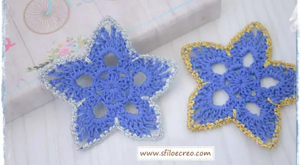 Stelline di Natale all'uncinetto schemi: due stelle azzurre con bordi argentati e dorati, perfette per decorare.