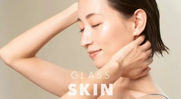 Kobieta z idealną, lśniącą cerą, która przypomina efekt glass skin. Jej skóra jest gładka i promienna.
