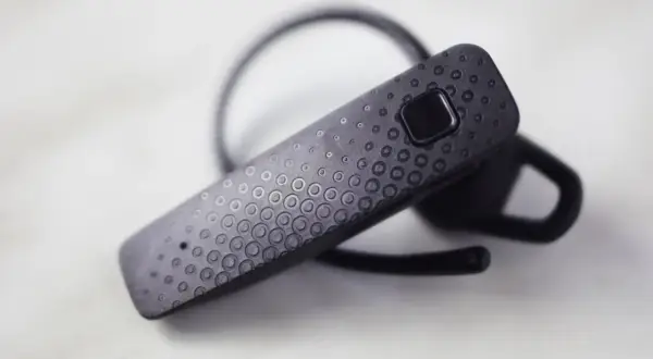 Czarna słuchawka Bluetooth z ozdobnym wzorem kółek. Dowiedz się, jak sparować słuchawki z telefonem, by cieszyć się muzyką bez kabli.