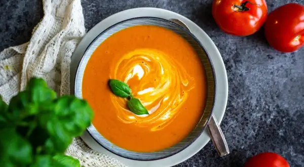 Krämig tomatsoppa med virvlar av grädde och färsk basilika. Ett perfekt tomatsoppa recept för en mysig kväll.