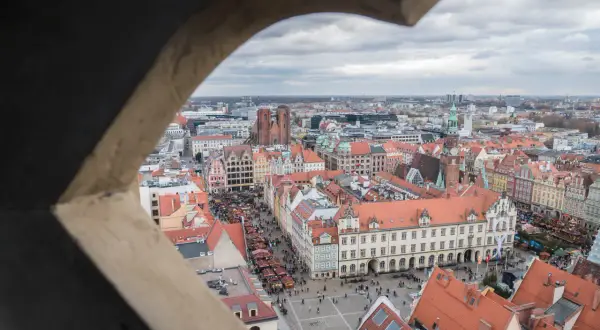 Widok z wieży widokowej we Wrocławiu na Rynek z jarmarkiem. W oddali katedra i inne zabytki.