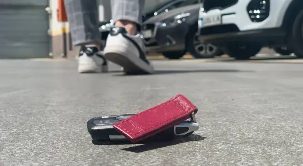 ¡Ay no! He perdido las llaves del coche. Están tiradas en el suelo, cerca de unos zapatos y coches aparcados.