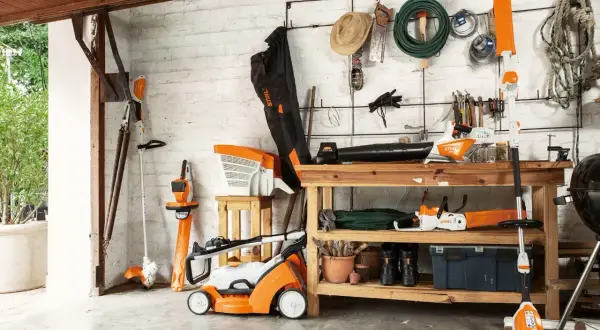 Herramientas de jardín Stihl, incluyendo cómo colgar una desbrozadora en la pared. Todo organizado en un cobertizo.