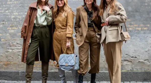 Vier Frauen in erdigen Tönen zeigen, was man bei 10 Grad anzieht: Leder-Trenchcoat, Anzüge und Stiefel.
