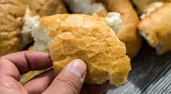 Czerstwy chleb w dłoni. Zastanawiasz się, co zrobić z czerstwego chleba? Idealny na grzanki lub bułkę tartą.