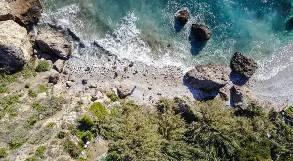 Vista aérea de la cala Barranco de Maro, con rocas, vegetación y el mar turquesa.