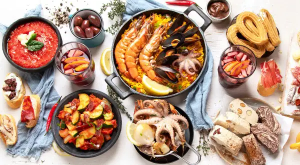 Pyszne hiszpańskie jedzenie: paella z owocami morza, tapas, churros i sangria.