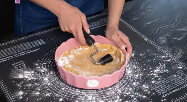 Sallys Kekse: Hände formen Teig in einer rosa Form auf einer Backmatte.